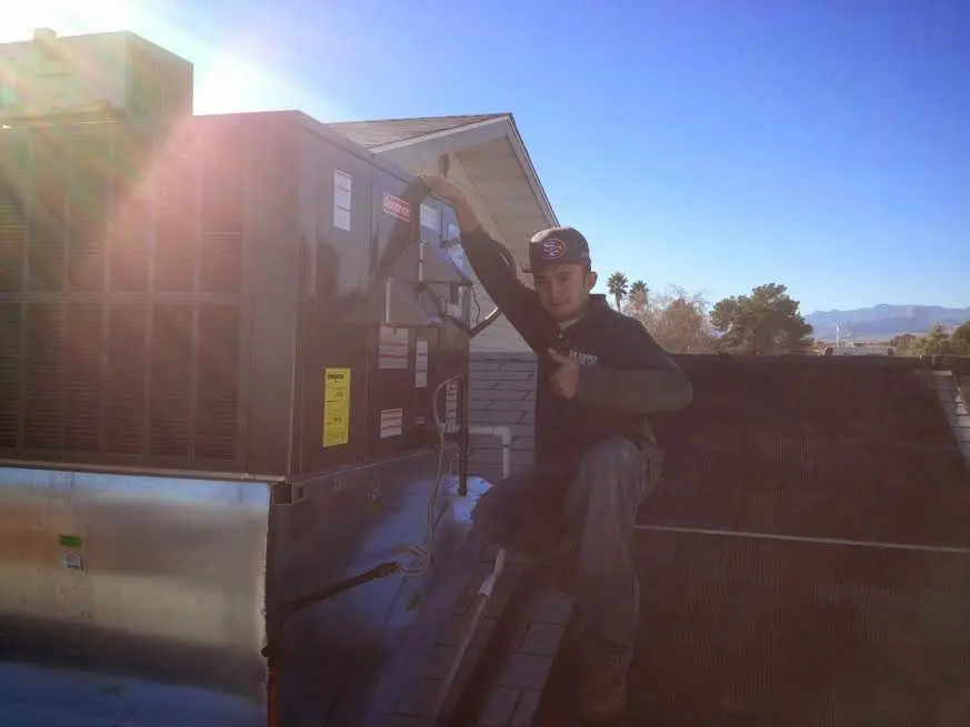 HVAC technician performing AC Tune-Up on a rooftop unit in St. Petersburg